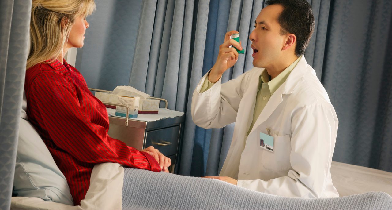 Doctor instructing patient with inhaler --- Image by © Don Hammond /Design Pics/Corbis