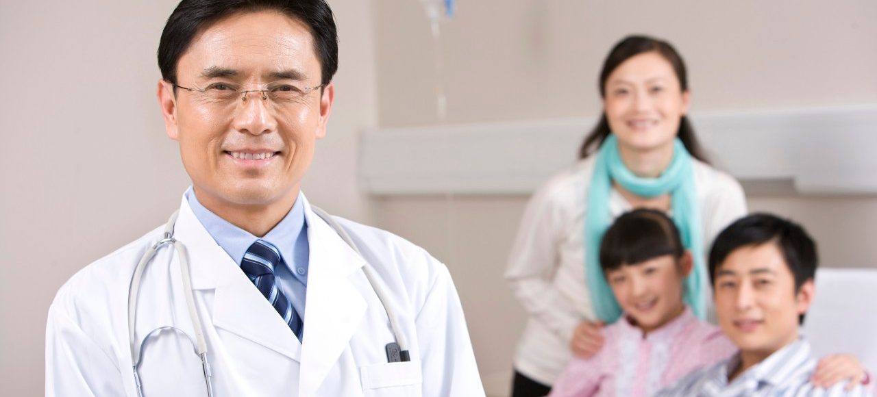 Kunming, Yunnan Province, China --- Portrait of a doctor with his patient and his patient's family --- Image by © Lane Oatey/Blue Jean Images/Corbis