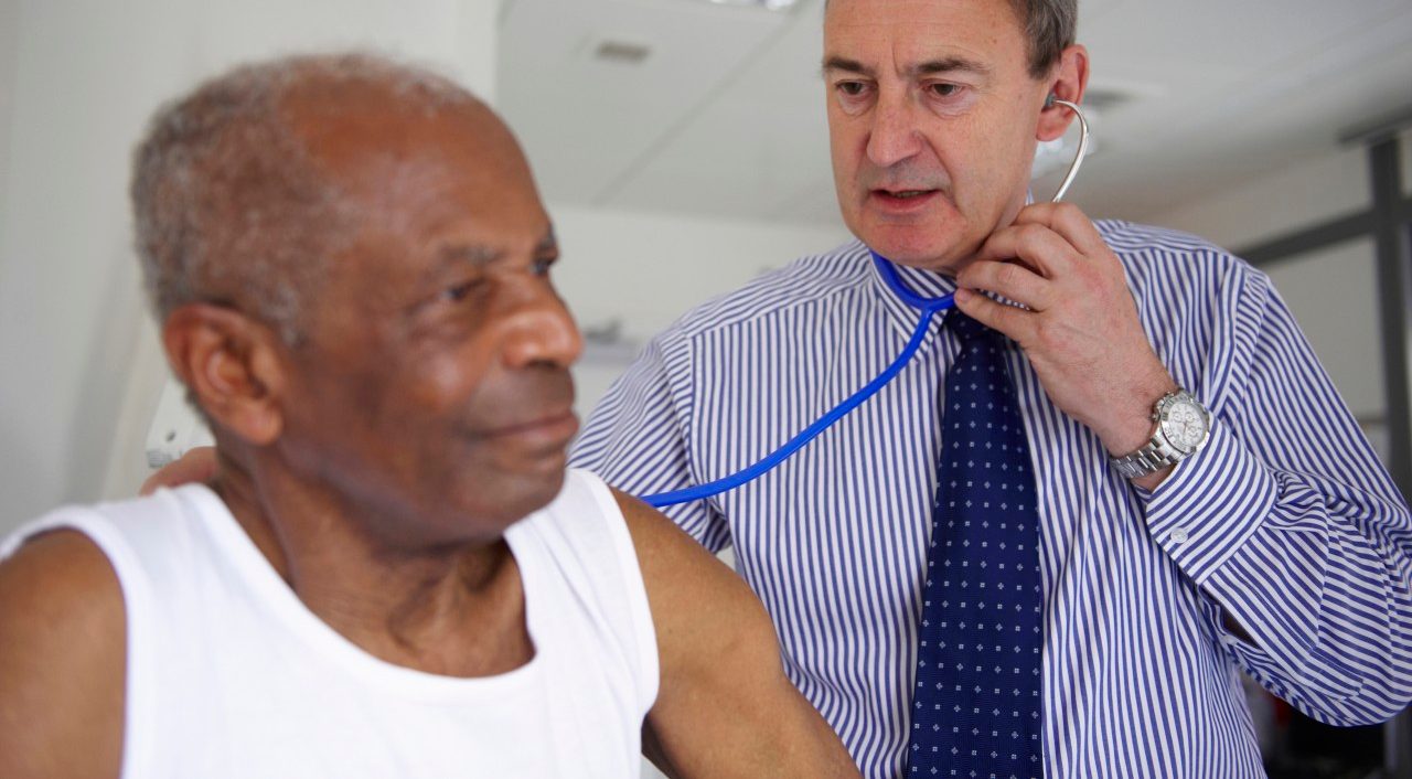 Doctor with stethoscope with elderly man --- Image by © Janie Airey/cultura/Corbis