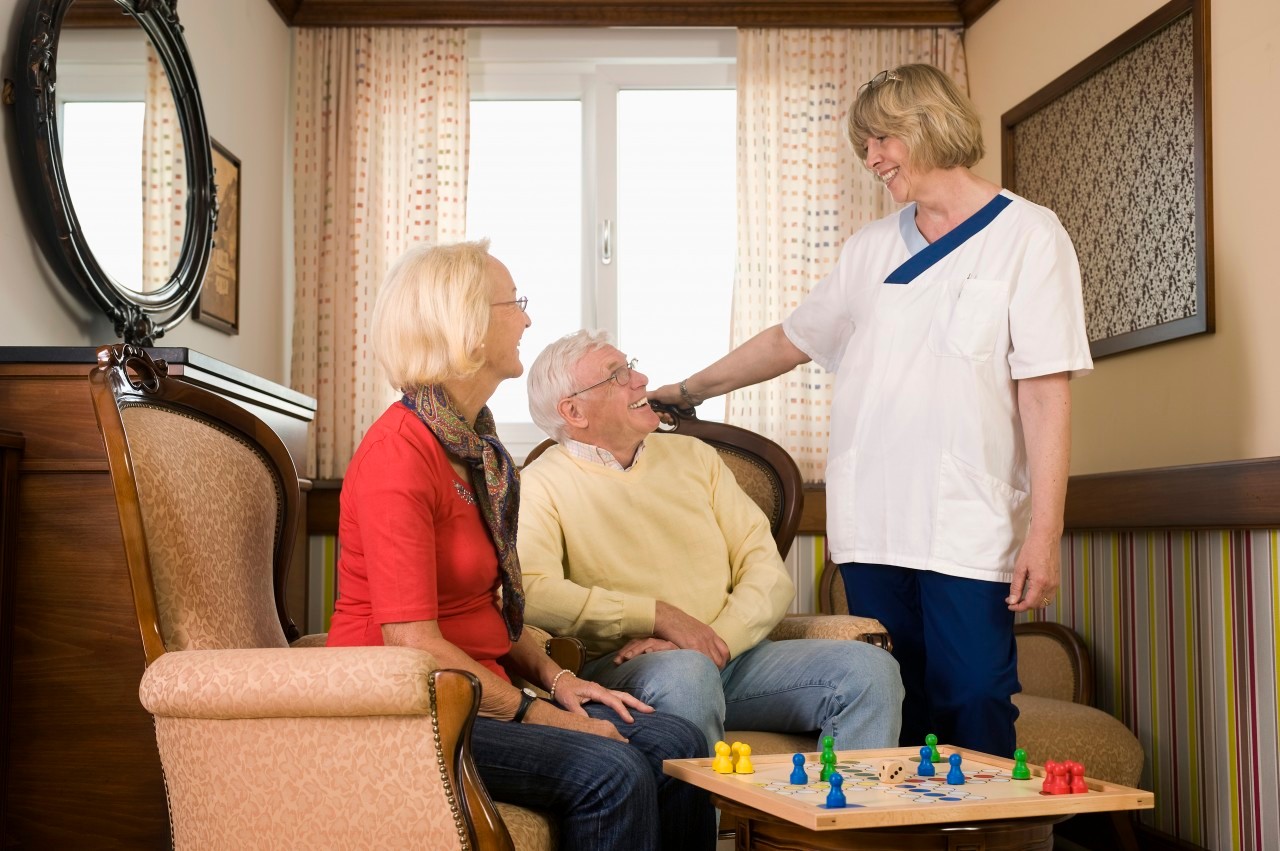 18 May 2012, Germany --- Senior couple and nurse, board game in foreground, Bavaria, Germany --- Image by © Robert Niedring/Horizontal/Lumi Images/Corbis