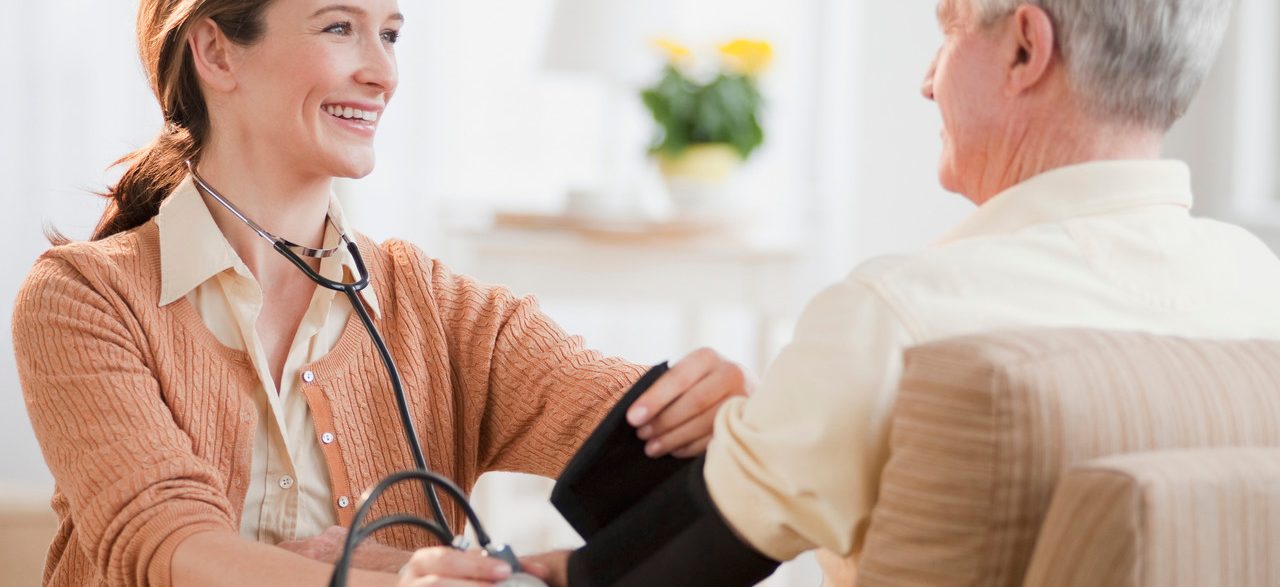 Nurse taking senior man's blood pressure --- Image by © Tetra Images/Corbis