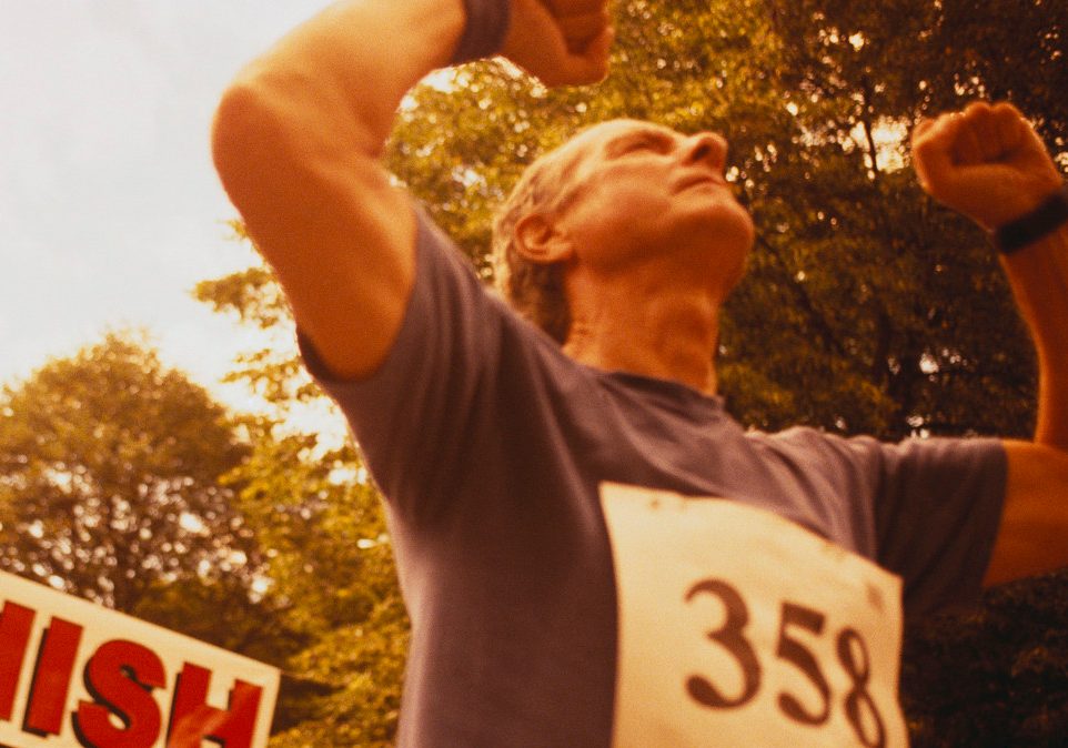 Elderly Runner Crossing Finish Line --- Image by © Dann Tardif/LWA/Corbis