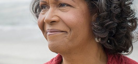 Portrait of elderly woman on beach --- Image by © Hiya Images/Corbis