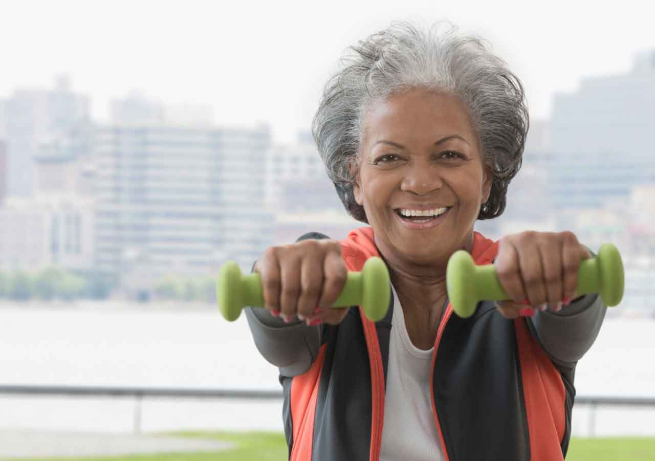 Portrait of elderly man lifting weights --- Image by © Jose Luis Pelaez, Inc./Blend Images/Corbis