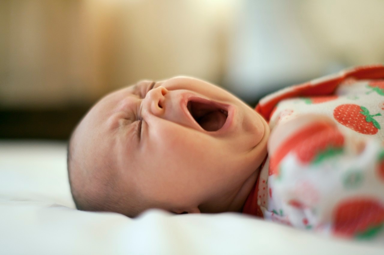Two month old baby lying down yawning --- Image by © MKeal/Corbis