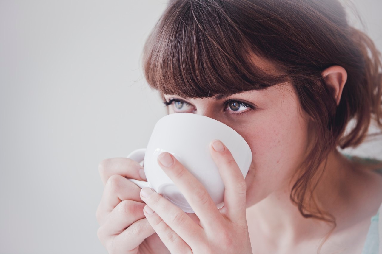 Young woman drinking tea --- Image by © Hannah Mentz/Corbis