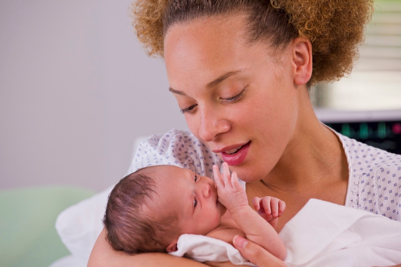 01 Jun 2012, Richmond, Virginia, USA --- Mixed race mother holding newborn baby --- Image by © Ariel Skelley/Blend Images/Corbis