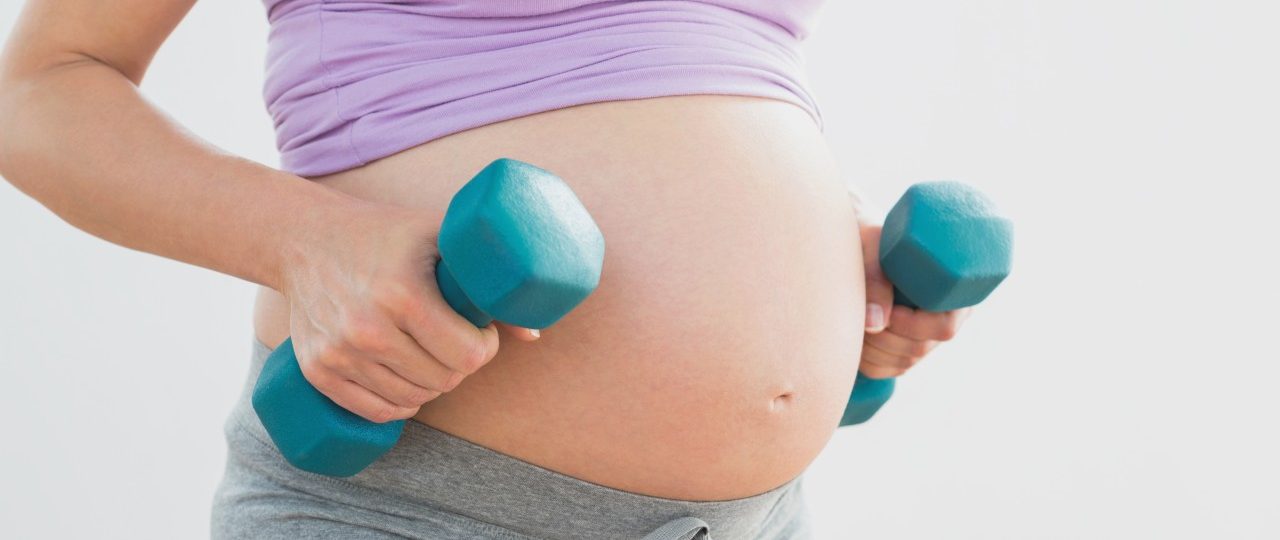 19 Nov 2013 --- Pregnant woman holding dumbbells --- Image by © Wavebreak Media LTD/Wavebreak Media Ltd./Corbis