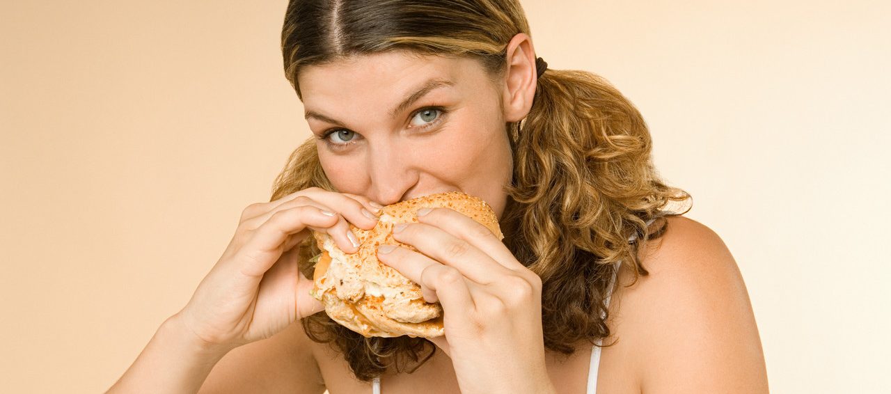 0042-11-30T00:00:00.000Z Woman eating a burger --- Image by © Image Source/Corbis