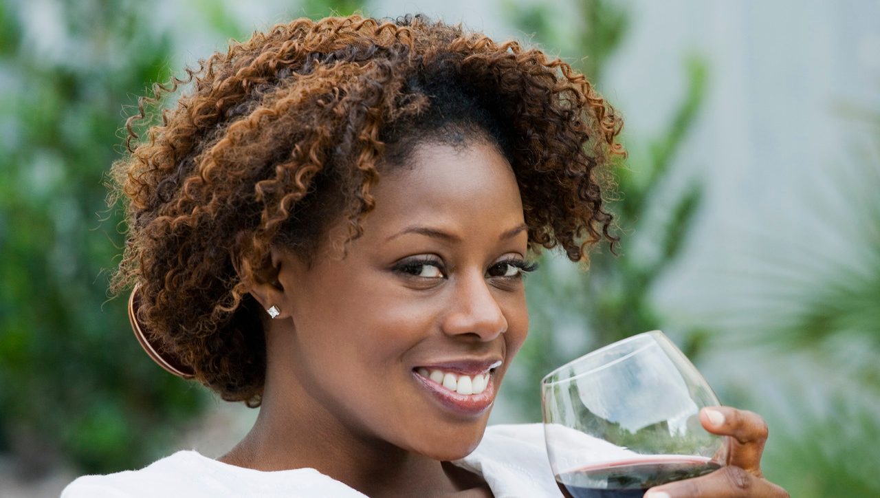 African American woman drinking red wine --- Image by © Inti St. Clair/Blend Images/Corbis