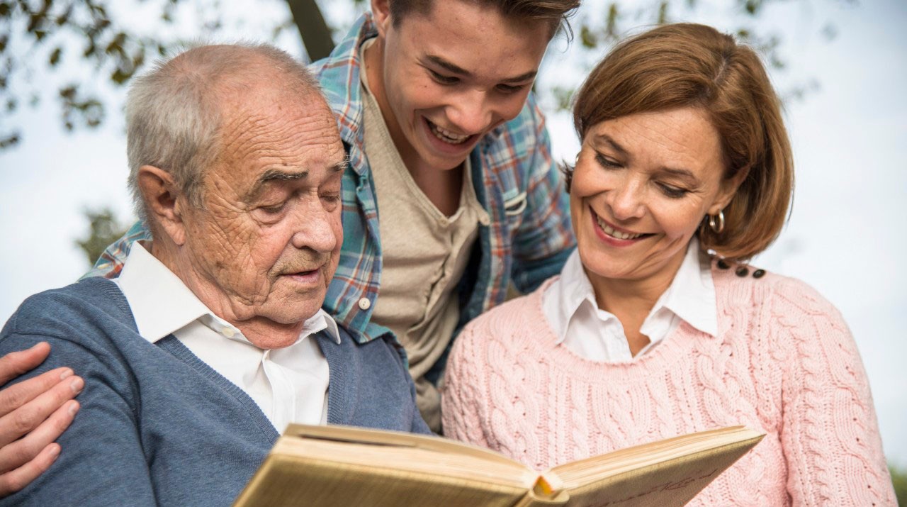 31 Oct 2014 --- Senior man with grandson and daughter looking at photo album --- Image by Â© Uwe UmstÃ¤tter/Westend61/Corbis