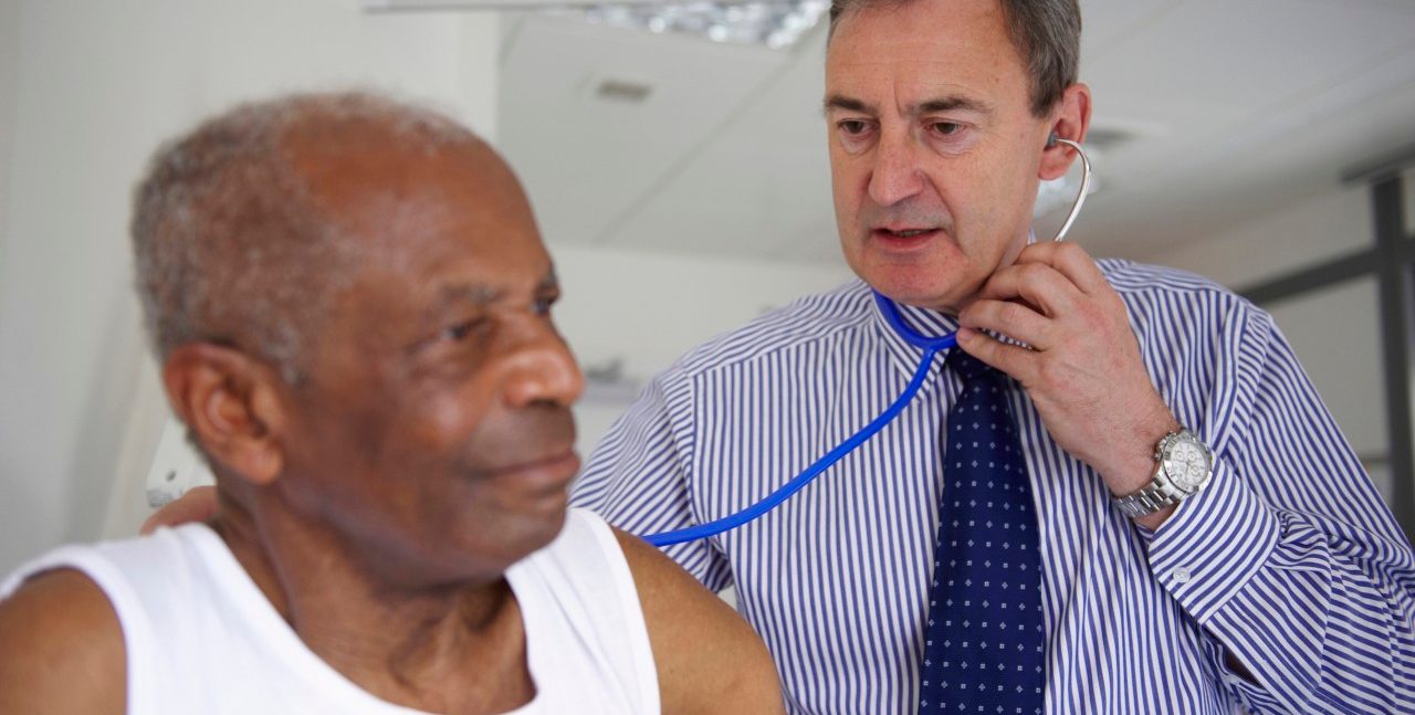 Doctor with stethoscope with elderly man --- Image by © Janie Airey/cultura/Corbis