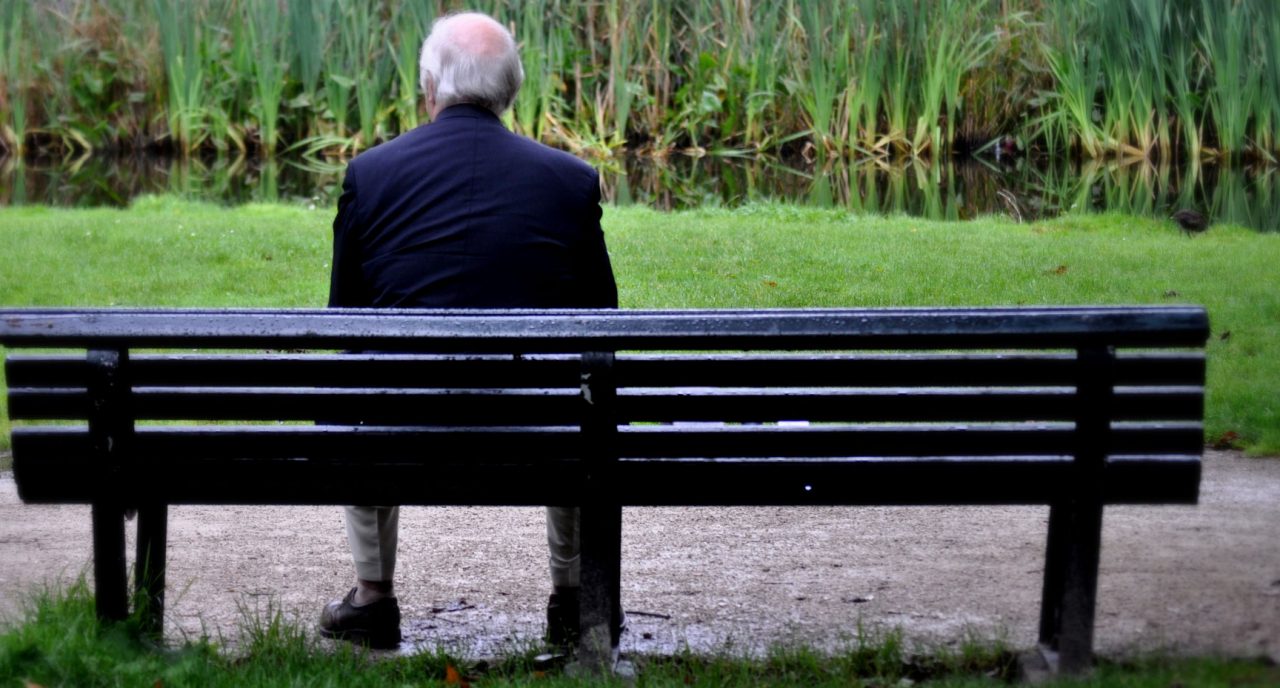 Older man alone on a park bench