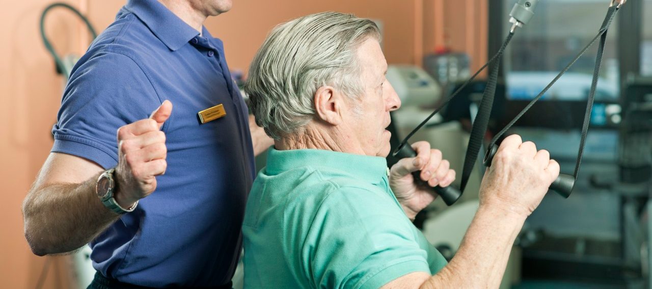 0042-11-30T00:00:00.000Z Trainer helping older man exercise --- Image by © Colin Hawkins/cultura/Corbis