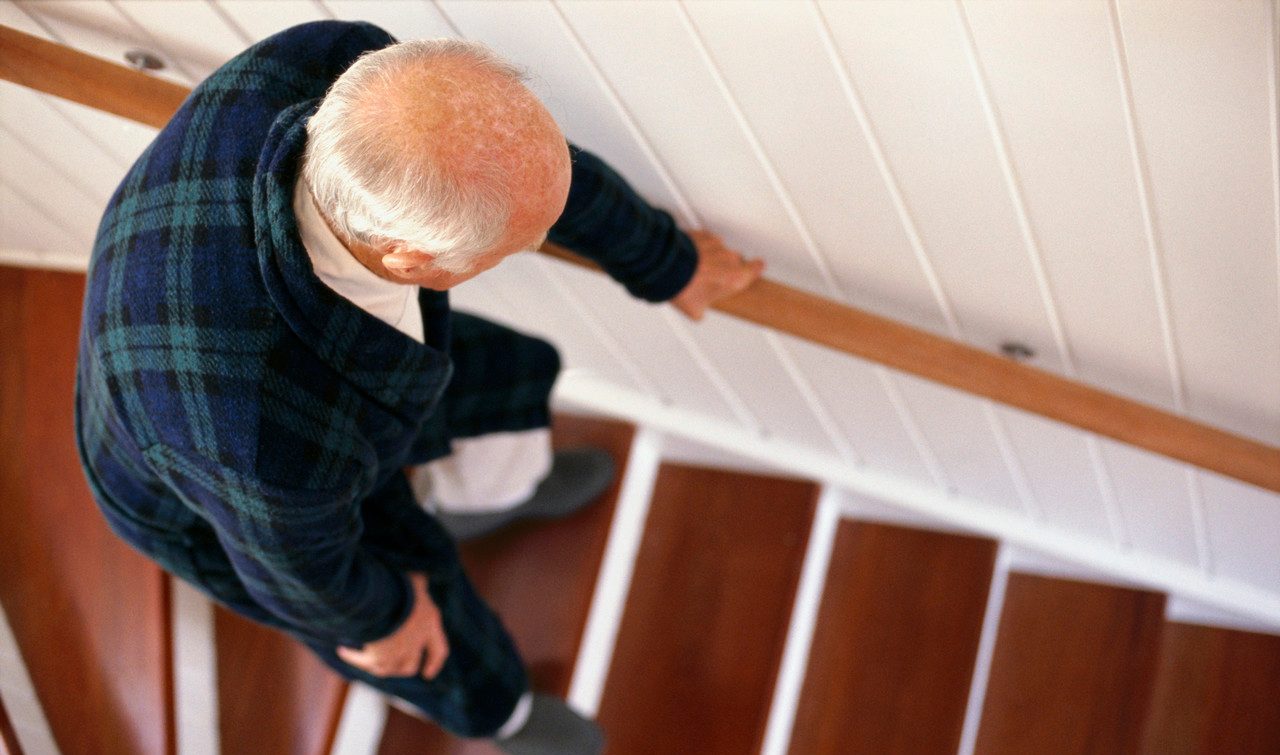 0042-11-30T00:00:00.000Z An elderly man carefully descends a staircase --- Image by © Whisson/Jordan/Corbis