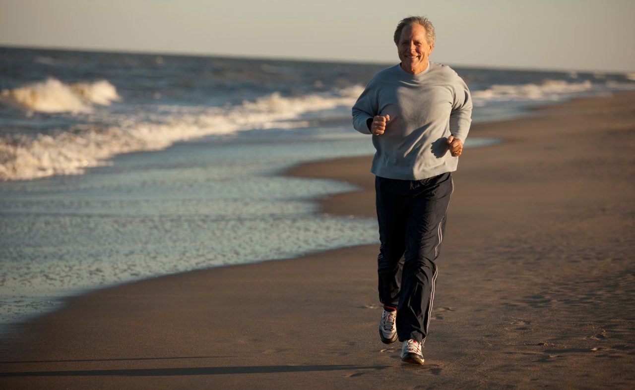 Virginia Beach, Virginia, USA --- Man running on beach --- Image by © John Henley/Blend Images/Corbis