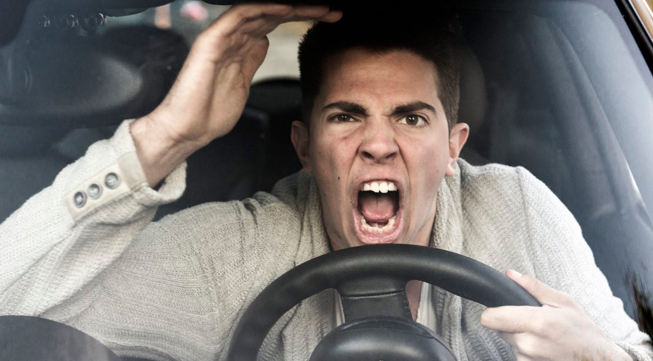 young man gets angry while driving the car --- Image by © Sandra Hoever/Corbis