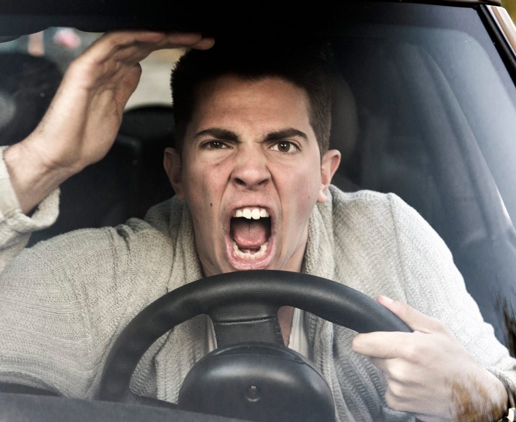 young man gets angry while driving the car --- Image by © Sandra Hoever/Corbis