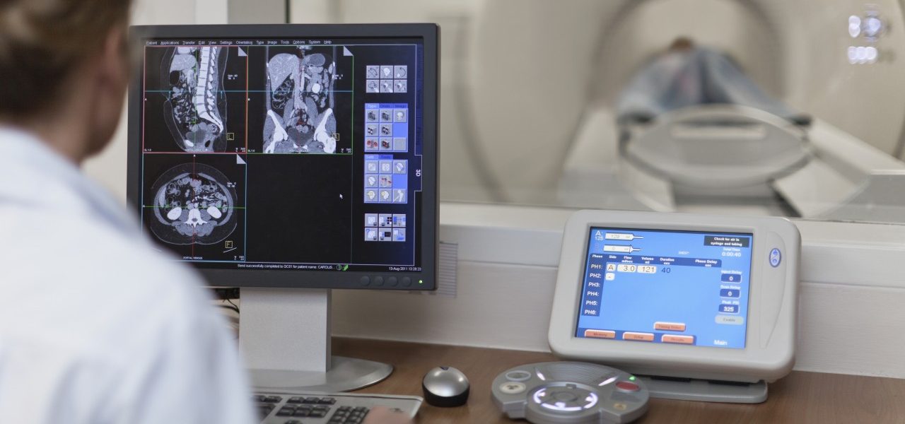 Doctor operating CT scanner in hospital --- Image by © Hybrid Images/cultura/Corbis