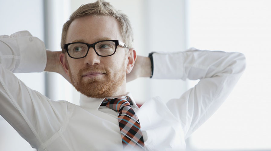 businessman with hands behind head --- Image by Â© Hero Images/Corbis