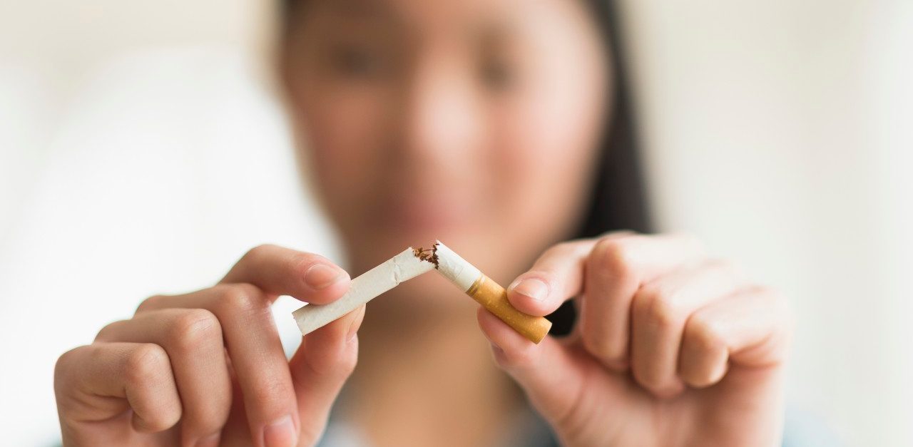 15 Apr 2014, Jersey City, New Jersey, USA --- Mixed race teenage girl breaking cigarette in half --- Image by © JGI/Tom Grill/Blend Images/Corbis