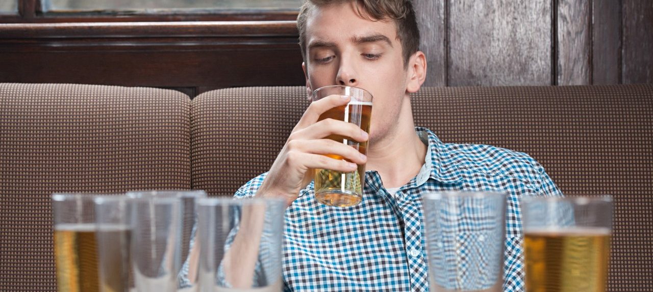 Young man drinking beer in bar --- Image by © Image Source/Corbis
