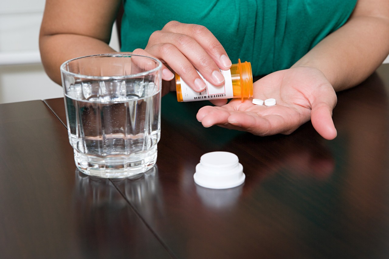 Woman Taking Tablets --- Image by © Image Source/Corbis