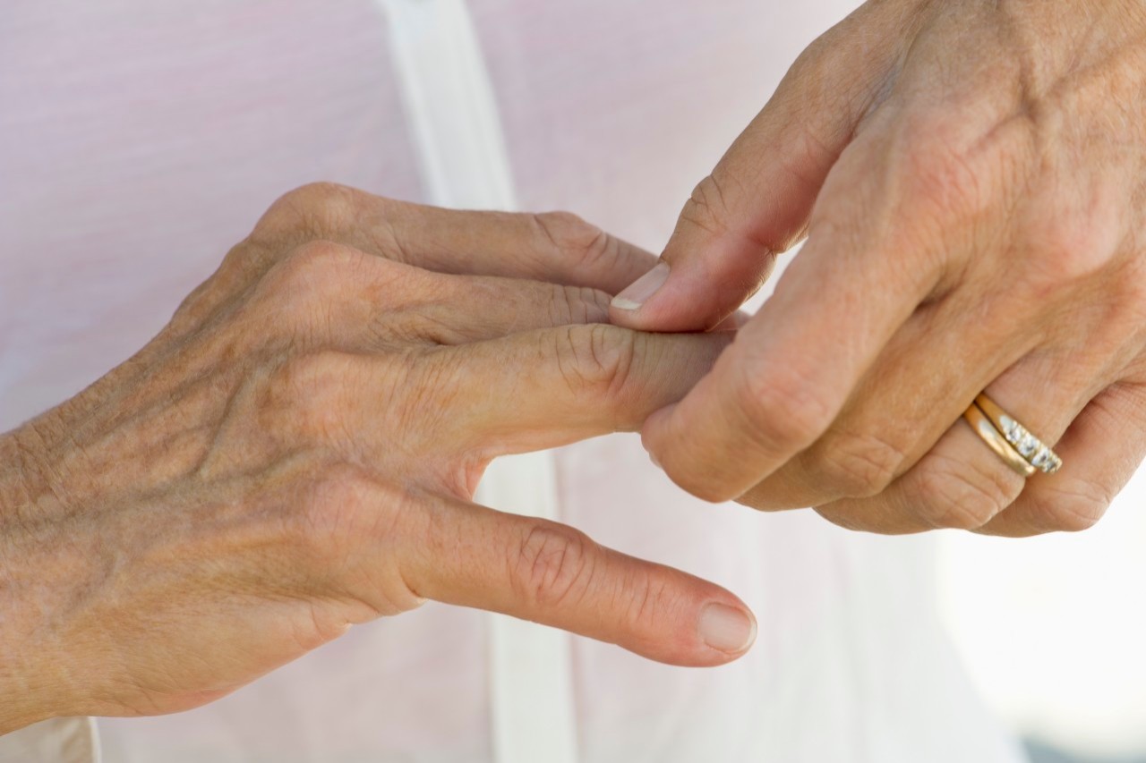 Senior woman rubbing knuckles, cropped --- Image by © Frederic Cirou/PhotoAlto/Corbis