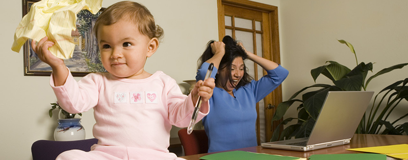 Baby Making Mischief on Mother's Desk --- Image by © Steve Hix/Somos Images/Corbis