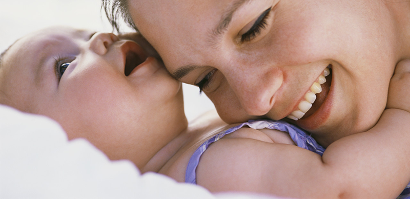 Mother Resting Head on Infant's Chest --- Image by © Tom Grill/Corbis