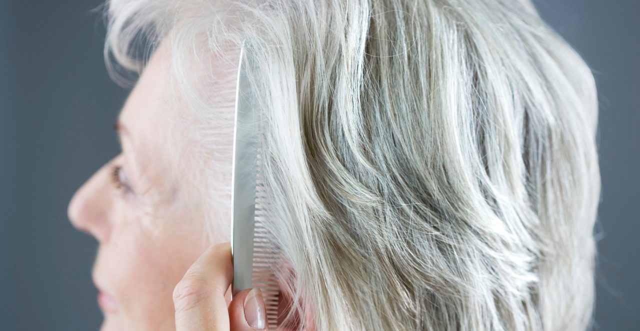 A senior woman combing her hair --- Image by © I Love Images/Corbis