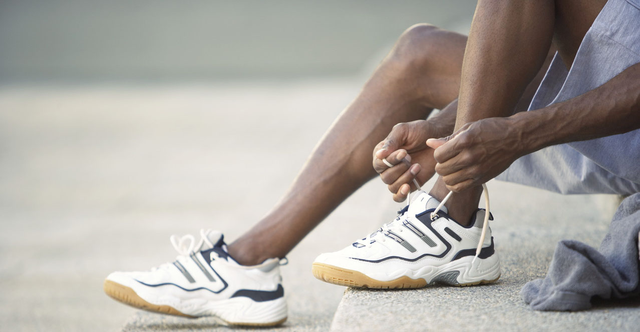 42-19744442 Man tying running shoes --- Image by © Oliver Eltinger/Corbis