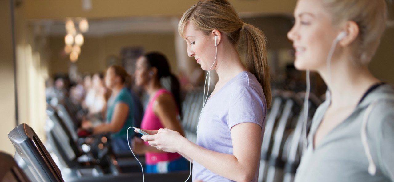 11 May 2012 --- Caucasian women using mp3 players on treadmills in gym --- Image by © Jose Luis Pelaez Inc/Blend Images/Corbis