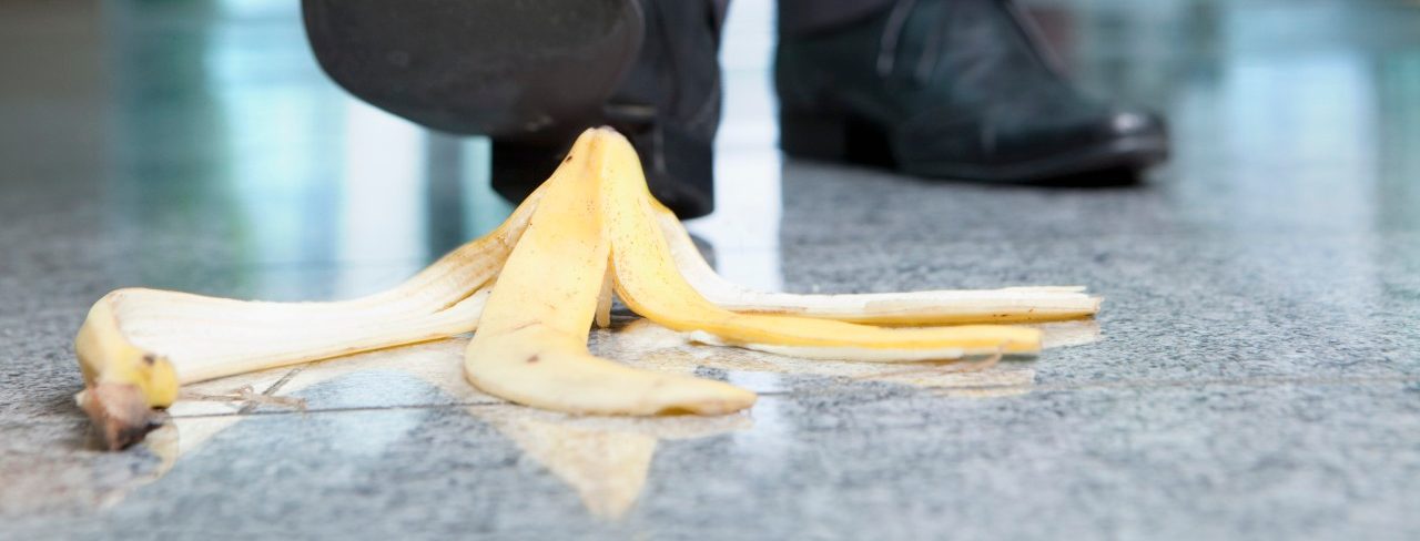 Businessman stepping on banana peel --- Image by © Juice Images/Corbis