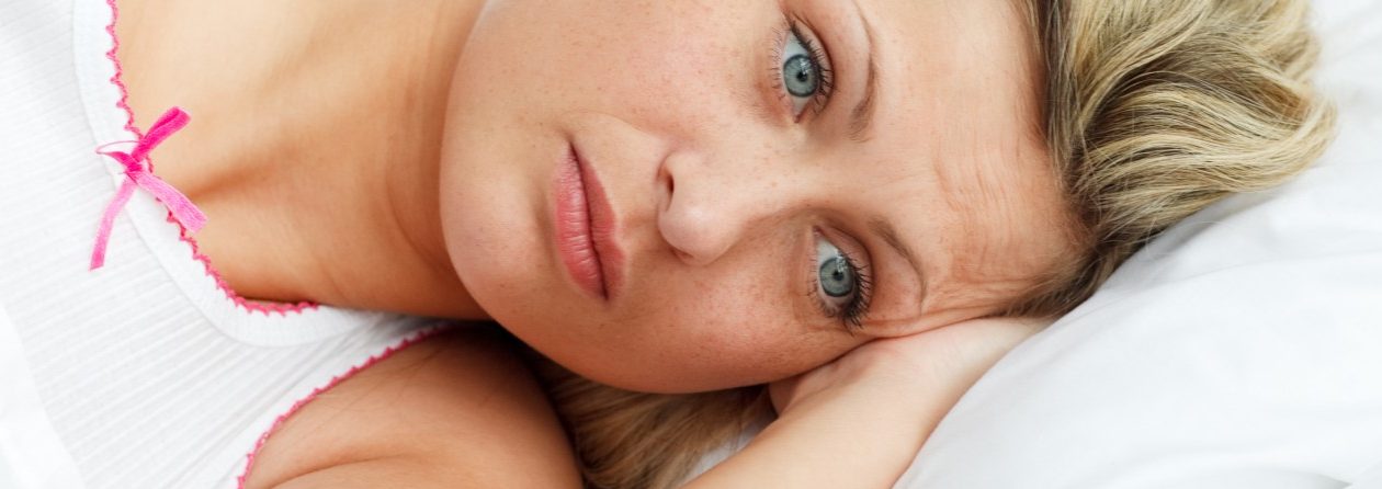 Portrait of upset woman lying in bed --- Image by © Wavebreak Media Ltd/Veer/Corbis