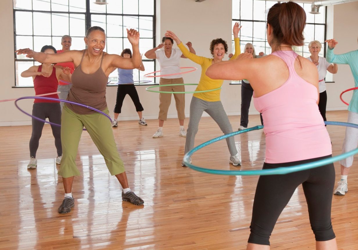 10 Apr 2011 --- Women spinning plastic hoops in fitness class --- Image by © Ariel Skelley/Blend Images/Corbis