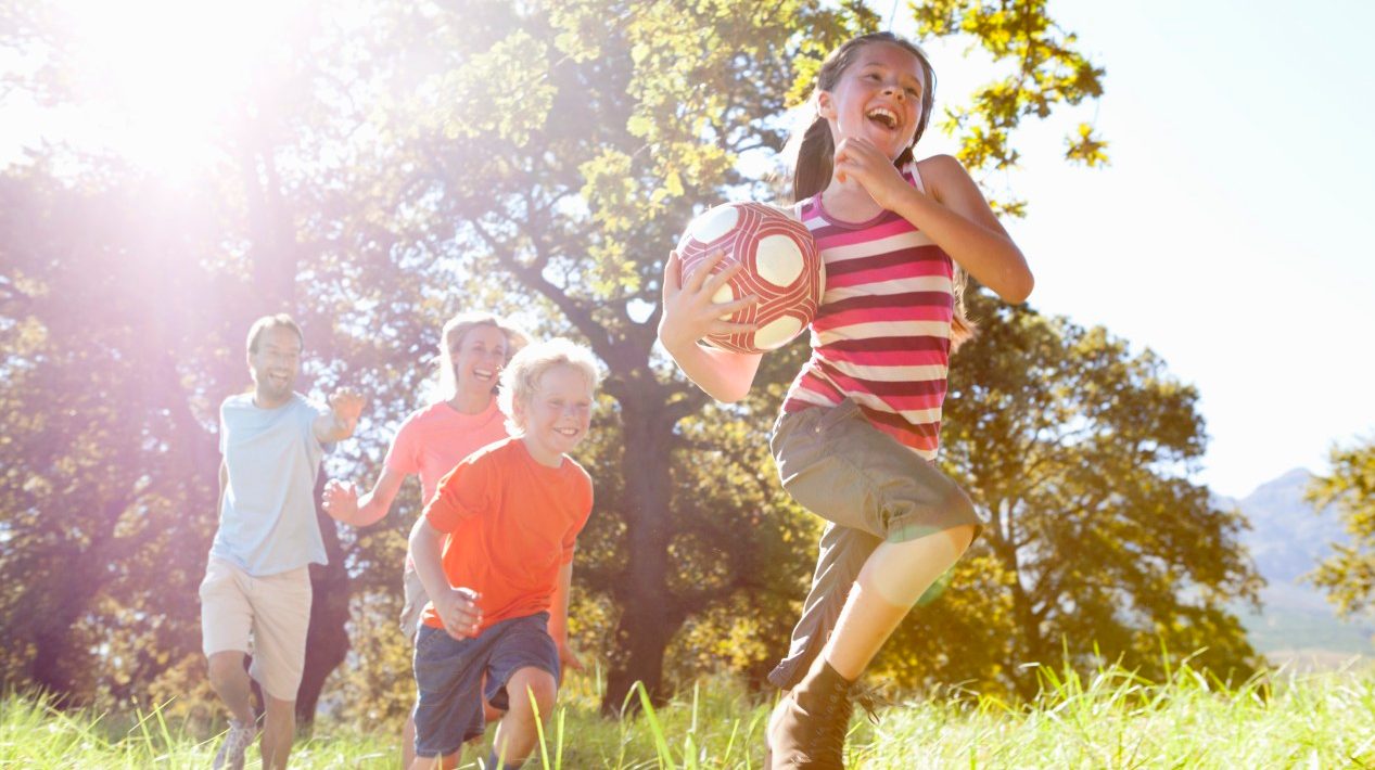 16 Sep 2014 --- Grandparents and grandchildren running with ball in rural field --- Image by © Ian Lishman/Juice Images/Corbis