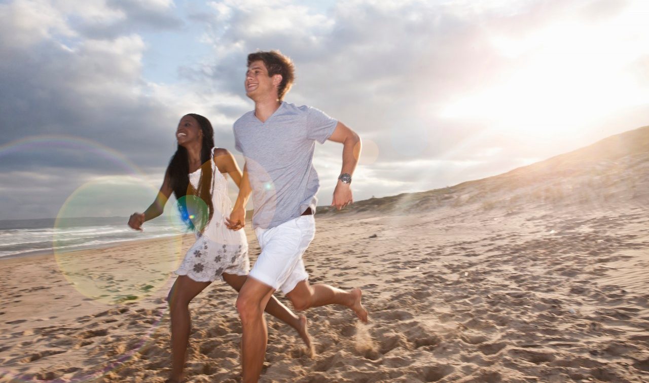 07 Feb 2014 --- Young couple running on beach --- Image by © Zero Creatives/Corbis