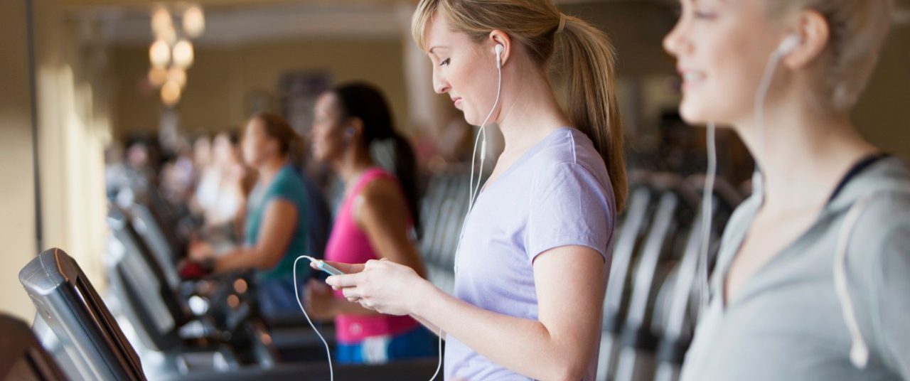 11 May 2012 --- Caucasian women using mp3 players on treadmills in gym --- Image by © Jose Luis Pelaez Inc/Blend Images/Corbis