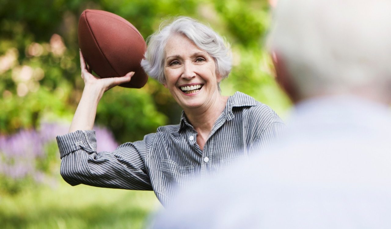 0042-11-30T00:00:00.000Z Senior woman throwing football to partner --- Image by © JOSE LUIS PELAEZ, INC./Image Source/Corbis