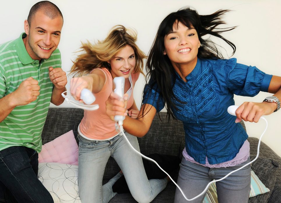 Portrait of friends playing video games --- Image by © Juice Images/Corbis