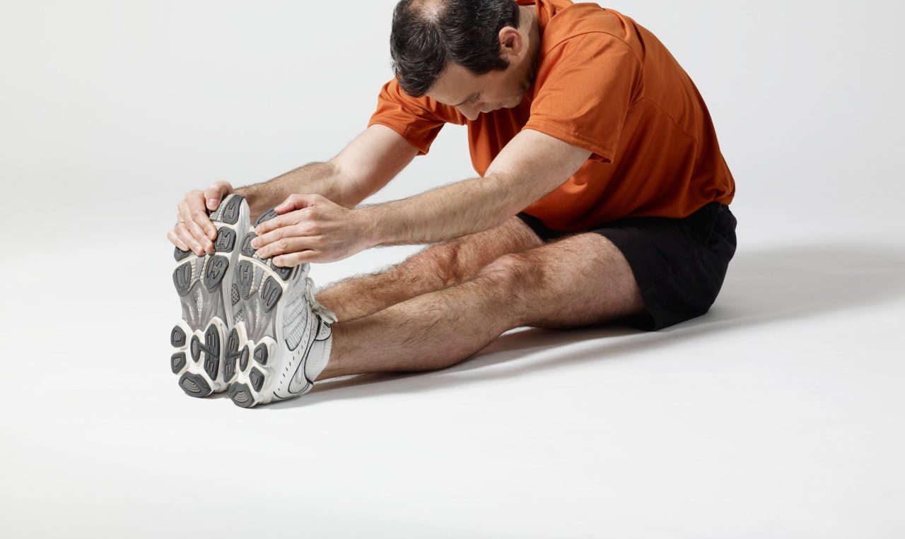 Man stretching --- Image by © Mark Weiss/Corbis