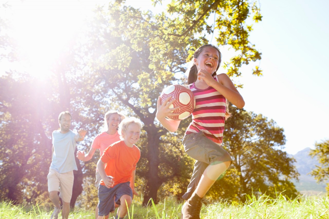 16 Sep 2014 --- Grandparents and grandchildren running with ball in rural field --- Image by © Ian Lishman/Juice Images/Corbis