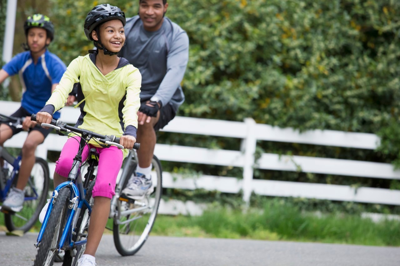 19 Apr 2013, Richmond, Virginia, USA --- Black family riding bicycles together --- Image by © Ariel Skelley/Blend Images/Corbis