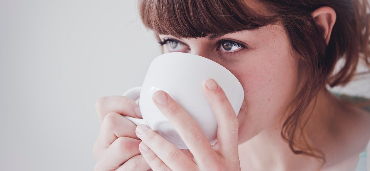 Young woman drinking tea --- Image by © Hannah Mentz/Corbis