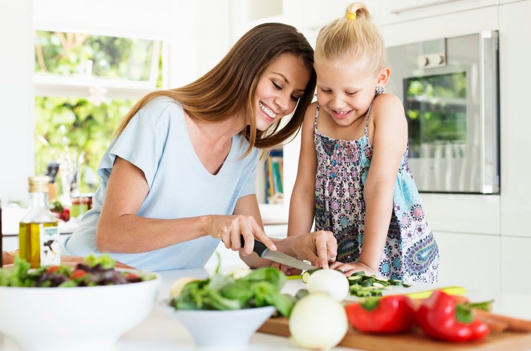 Mother and daughter (4-5) preparing food in kitchen --- Image by © Tomas Rodriguez/Corbis