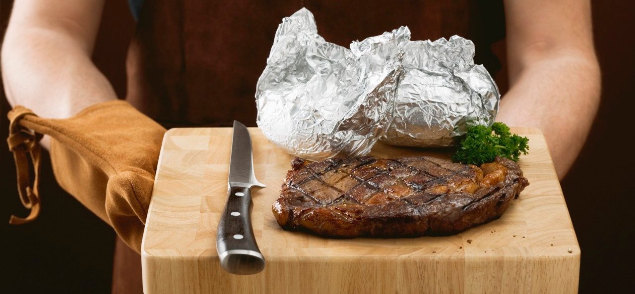 0042-11-30T00:00:00.000Z 02 May 2007 --- Man holding grilled beef steak on chopping board --- Image by © the food passionates/Corbis