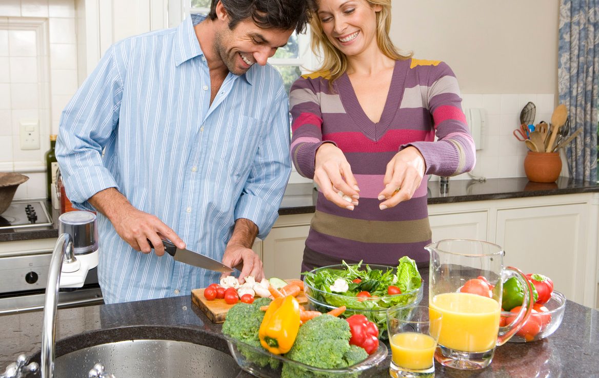 Man and woman making salad --- Image by © Juice Images/Corbis