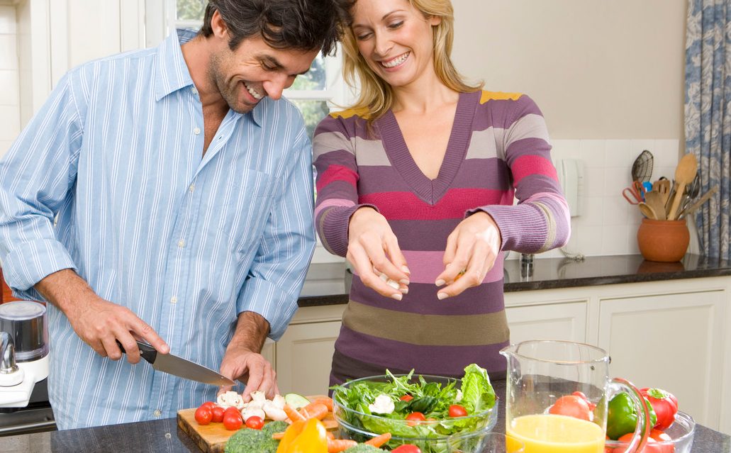 Man and woman making salad --- Image by © Juice Images/Corbis