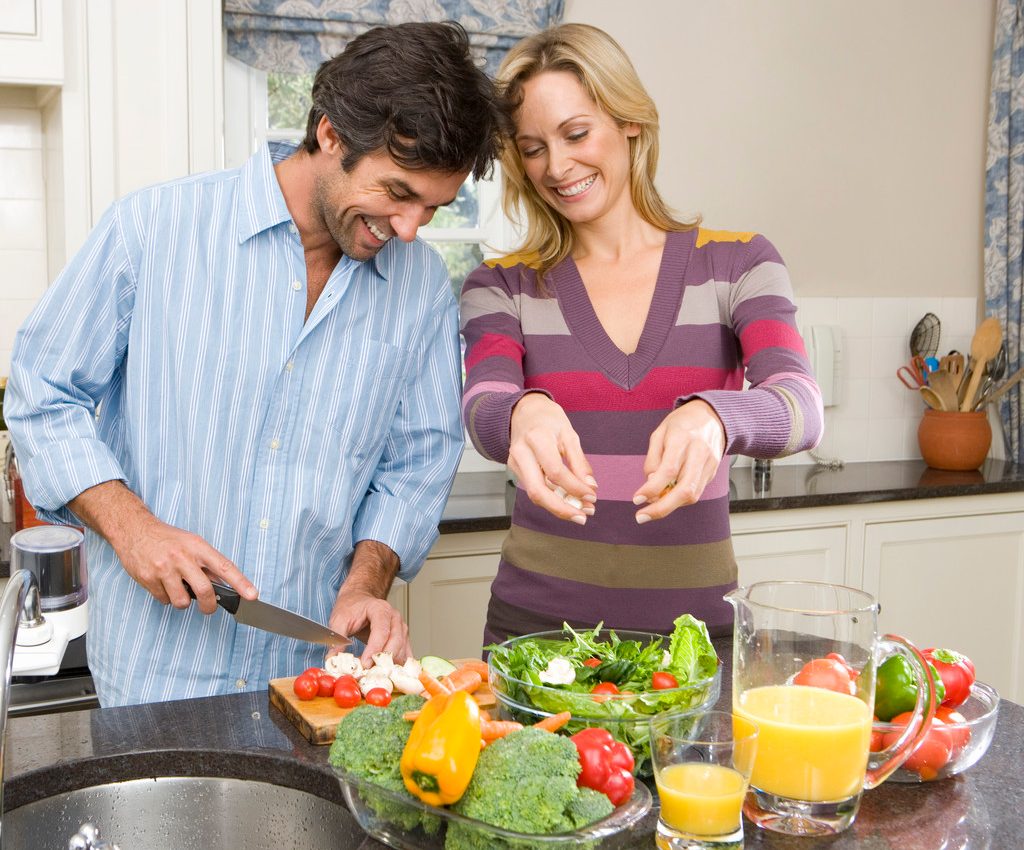 Man and woman making salad --- Image by © Juice Images/Corbis